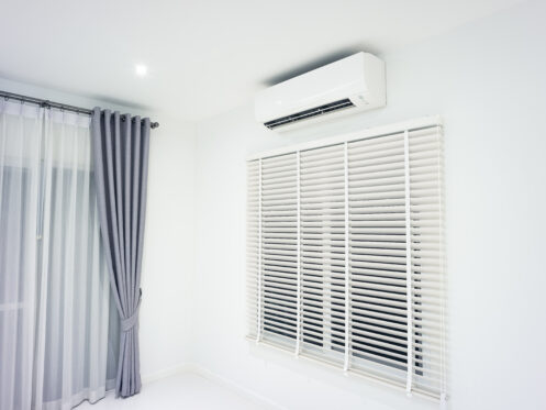 Wall-mounted ductless mini-split air handler over a window